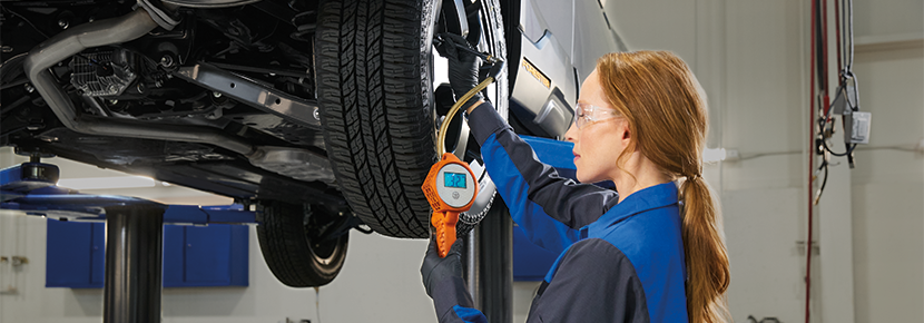A Subaru technician checking tire pressure. | Flow Subaru in Winston-Salem NC