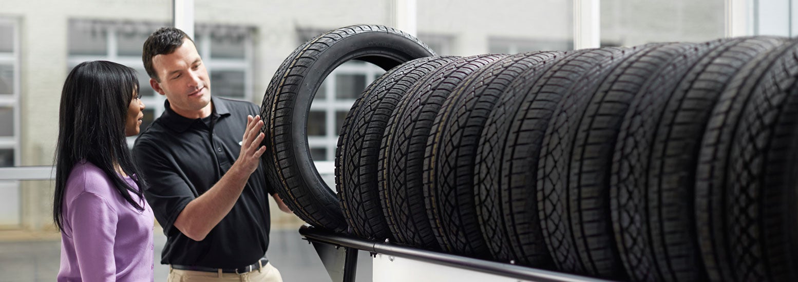 Subaru service representative showing customer a tire. | Flow Subaru in Winston-Salem NC